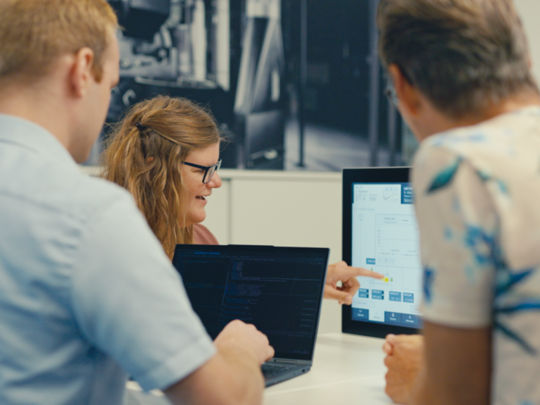 Three people looking at screen