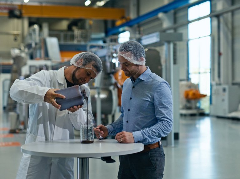 Two men standing in the technology center in Dresden, testing material