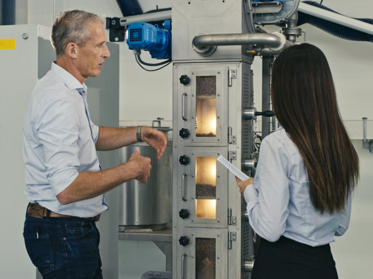 Picture shows a Probat employee explaning a machine of the foos sector to a customer.