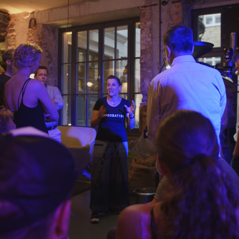 Probat Employee Daniela is standing in front of some people during an event explaining the world of coffee roasting