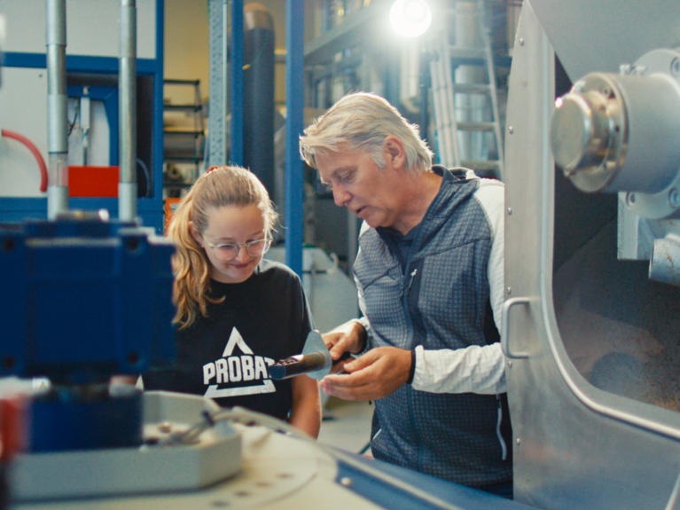 PROBAT employees at work in the factory. An older colleague is explaining something to a girl