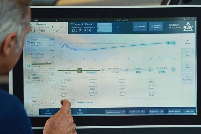 A man is standing in front of a screen showing the Probat roasting software