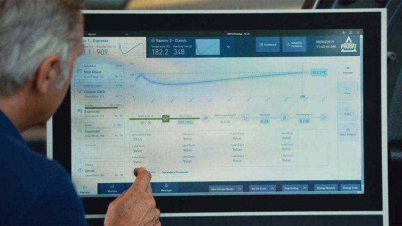 A man is standing in front of a screen showing the Probat roasting software